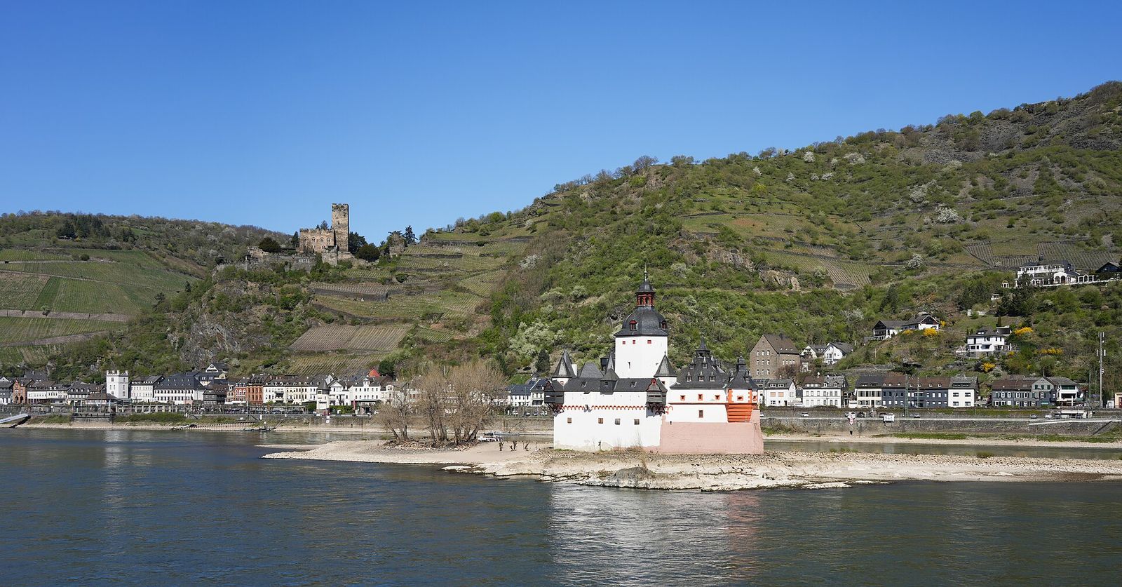 Die weiße Zollburg Pfalzgrafenstein auf einer Felsinsel im Rhein vor Kaub, am Hang darüber Burg Gutenfels zwischen Weinbergen