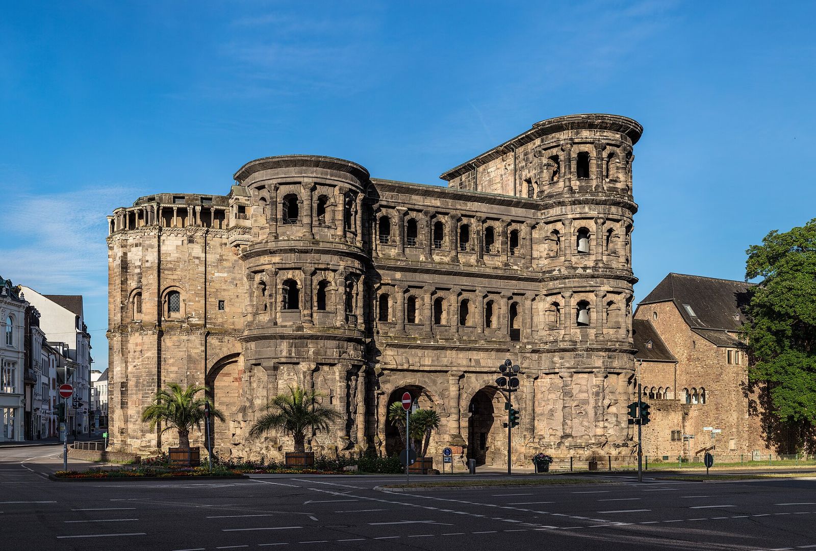 Das römische Stadttor Porta Nigra in Trier aus dunklem Sandstein mit Bogenfenstern im Morgenlicht