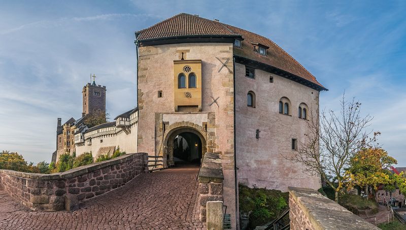 Gepflasterte Brücke zum Torhaus der Wartburg, links dahinter Wehrgang und Bergfried in warmem Licht